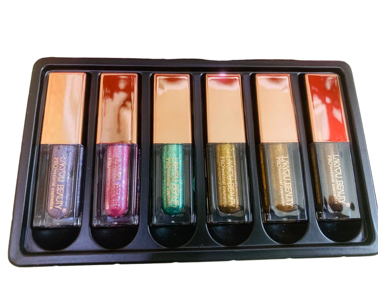 Set of metallic glow liquid eyeshadow in a black tray with visible brand name.